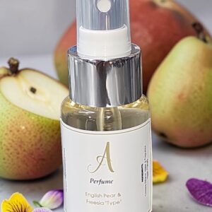Perfume spray bottle with a silver cap, label reads 'Perfume' and 'English Pear & Freesia Type' with pears in the background and flowers around.